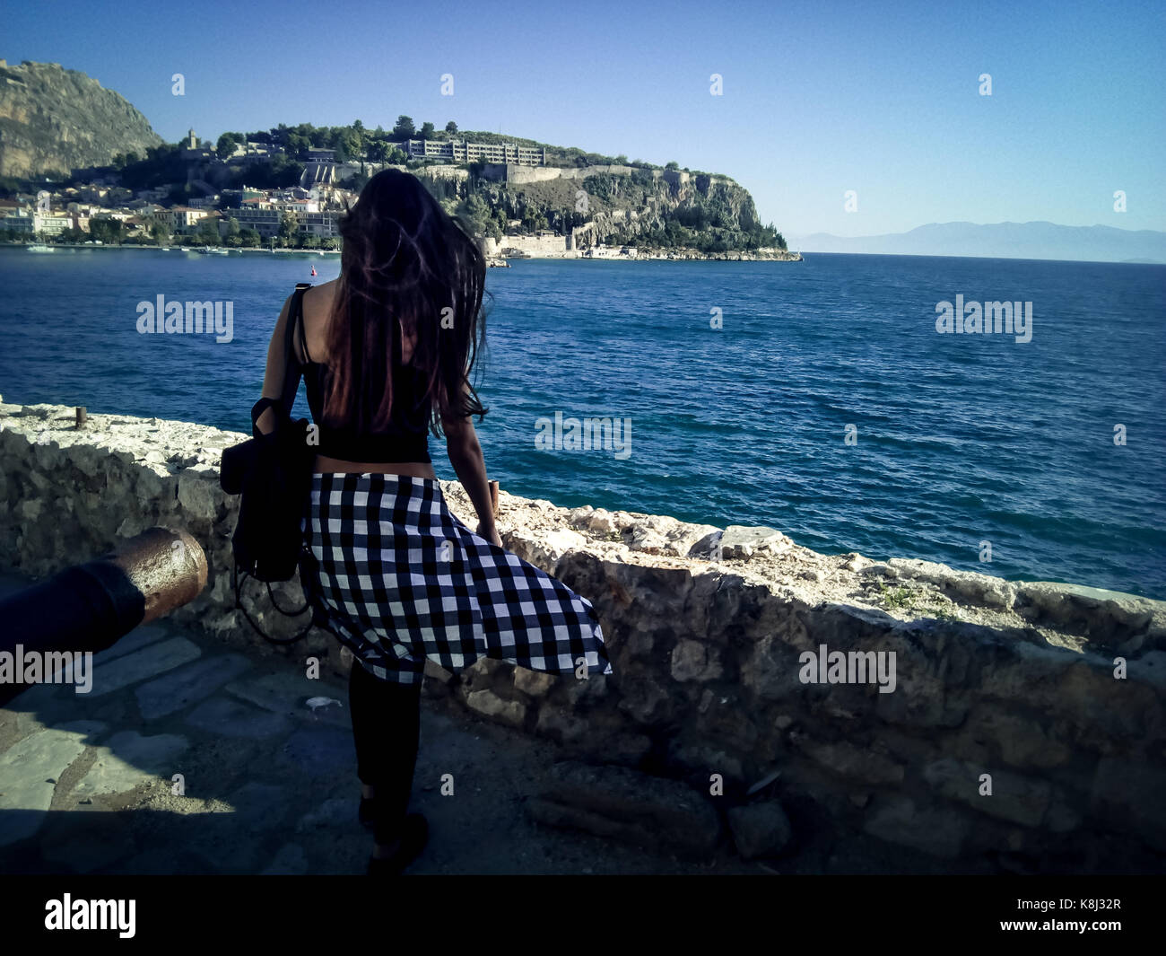 woman and sea. Girl walking in front of my camera gazing the ocean and the nearby islands standing on a fort Stock Photo