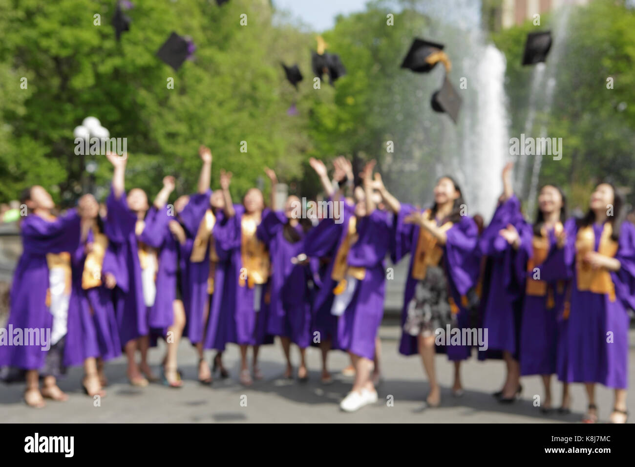 New York, NY, USA - May 16, 2017: Out of focus photo of New York University students, in caps and gowns, gathered in Washington Square Park Stock Photo