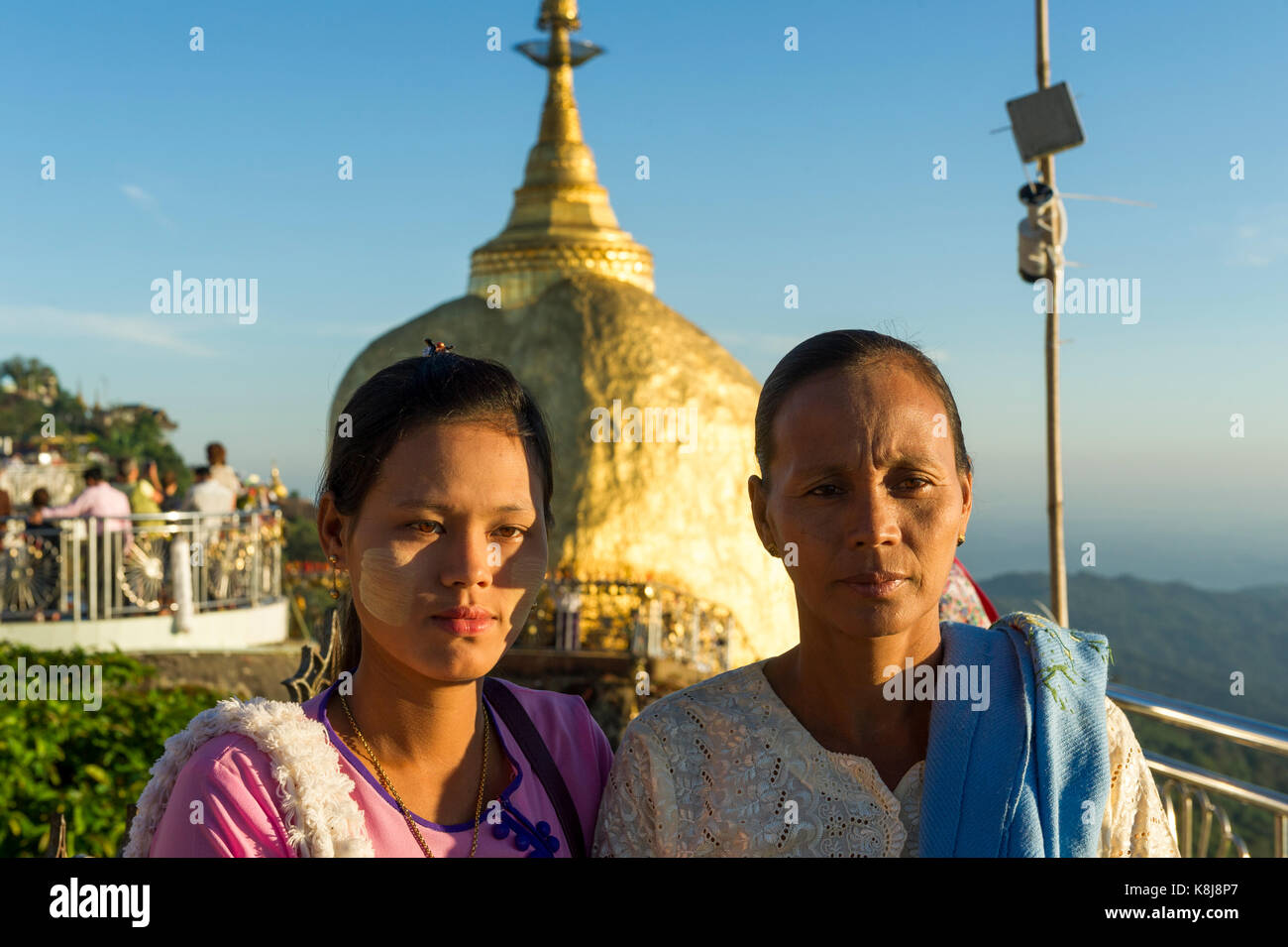 Myanmar (formerly Burma). Kyaiktiyo. State Mon. Sacred site of the golden rock. Burmese pilgrims photographing in front of the rock Stock Photo