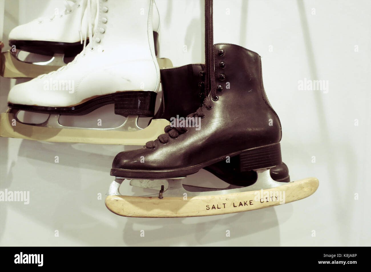 Two pairs of old fashioned ice skates hung on the wall Stock Photo - Alamy