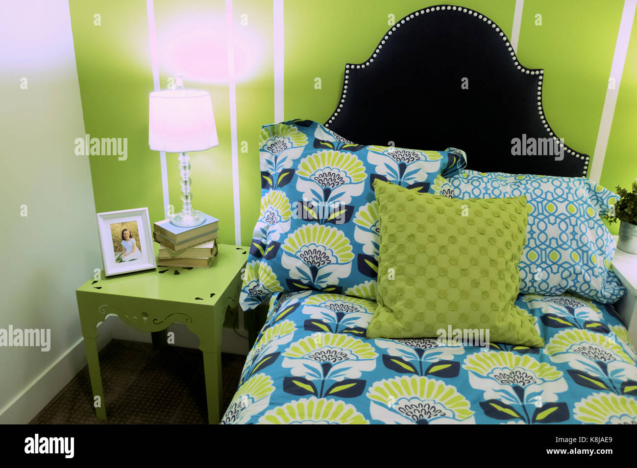 A Bright Green Bedroom With A Small Bed And A Cute