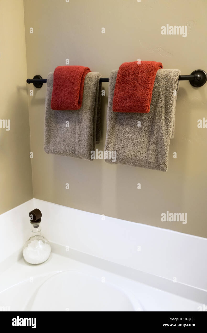 A black towel bar with gray towels and red washcloths and a bottle of powder Stock Photo Alamy