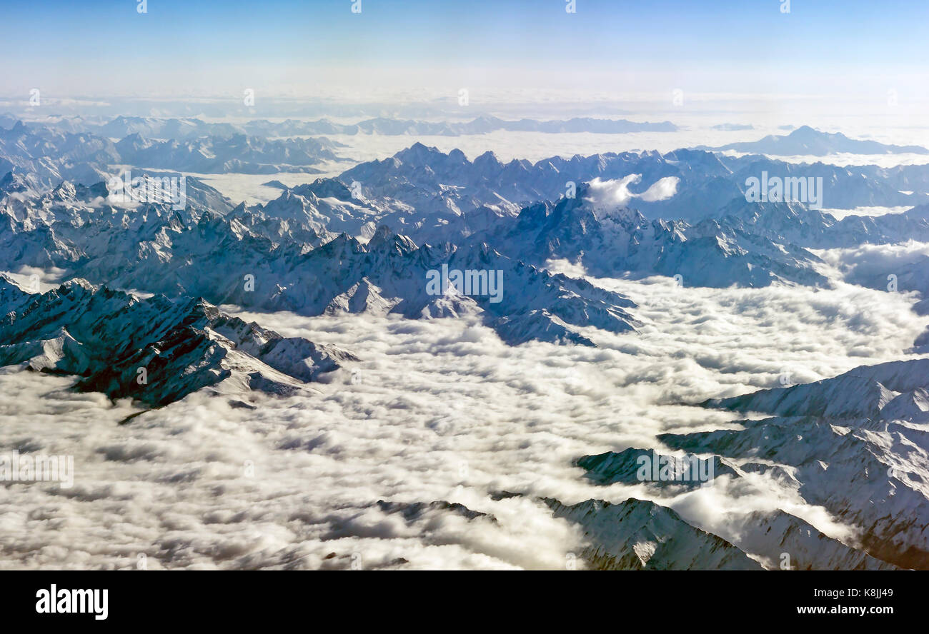 Himalaya mountains under clouds. View from airplane - Tibet Stock Photo