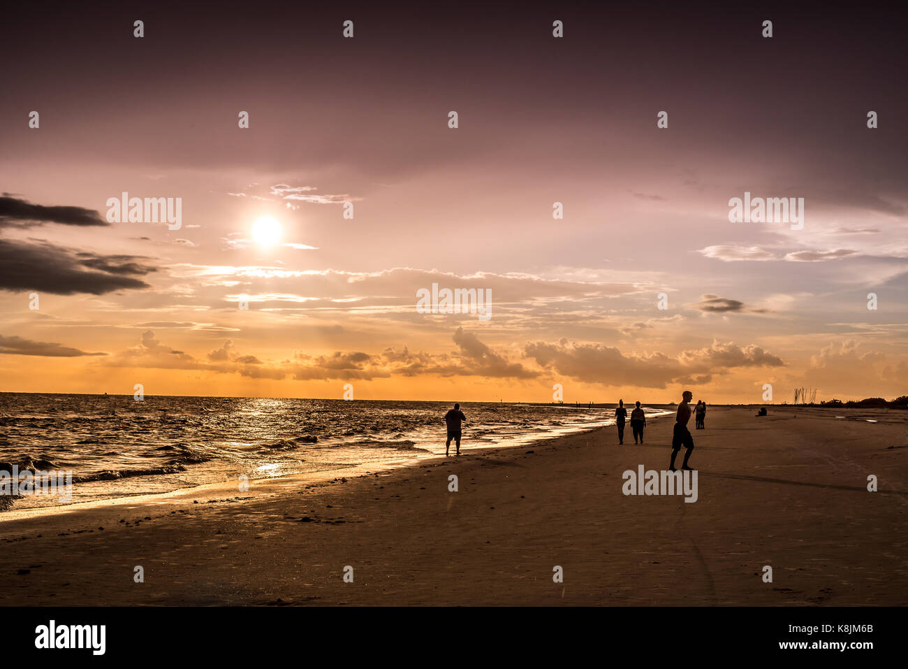 sunset at the beach with silhouettes Stock Photo - Alamy