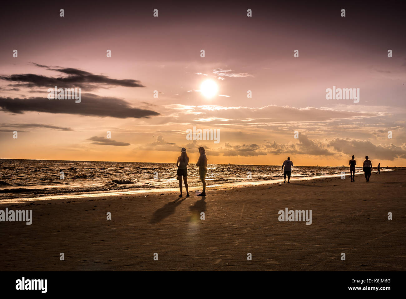 sunset at the beach with silhouettes Stock Photo - Alamy