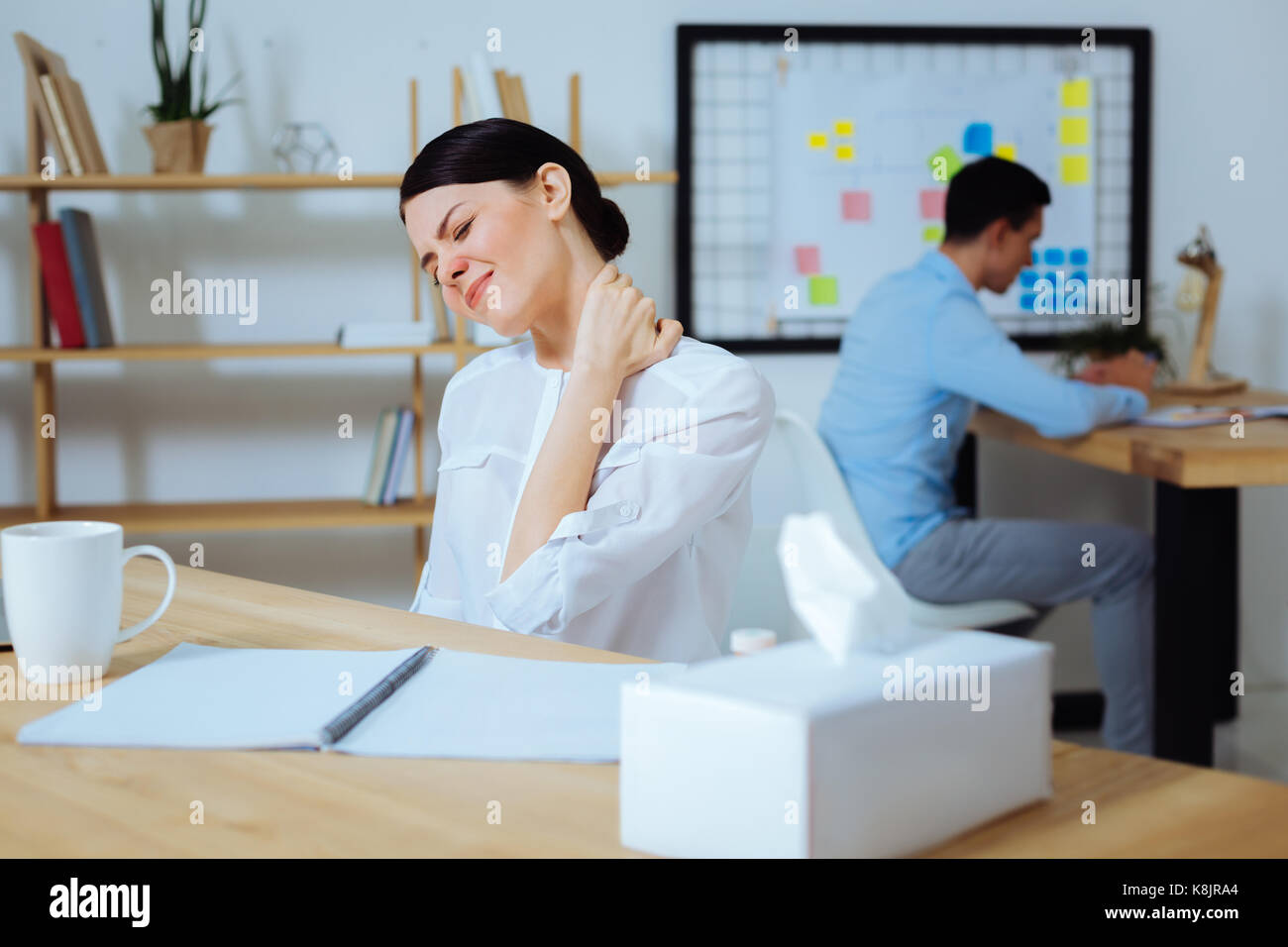 Tired office worker massaging her neck Stock Photo - Alamy