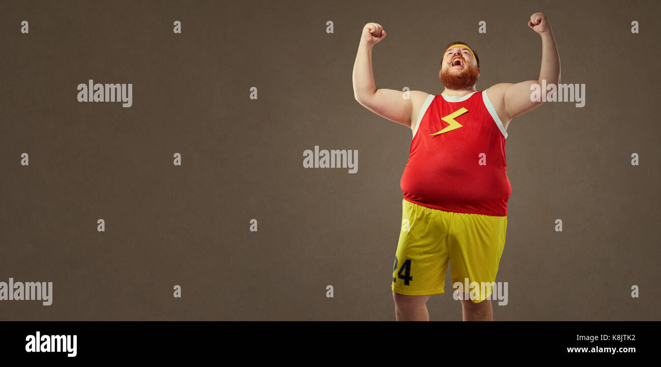 A fat man in sports clothes screams at the victory. Stock Photo