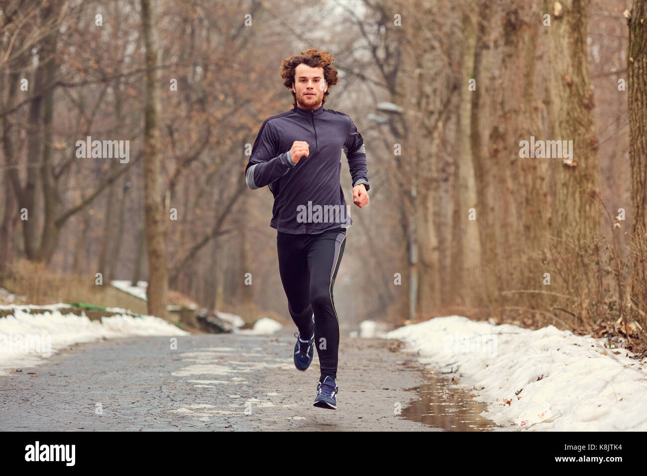 A young male runner runs in the park. Stock Photo