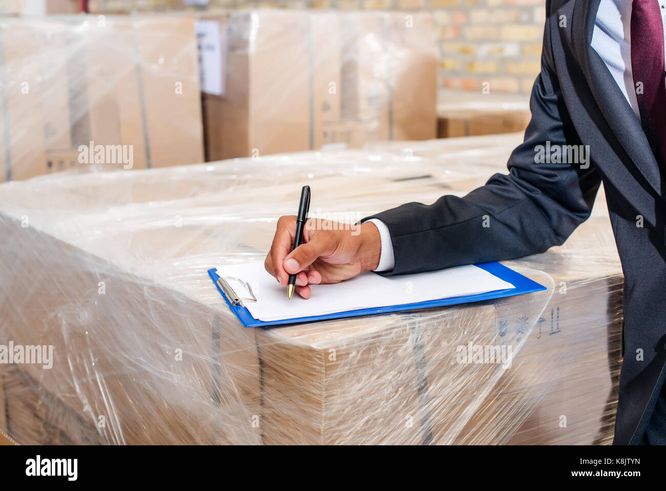 businessman writing on clipboard Stock Photo - Alamy