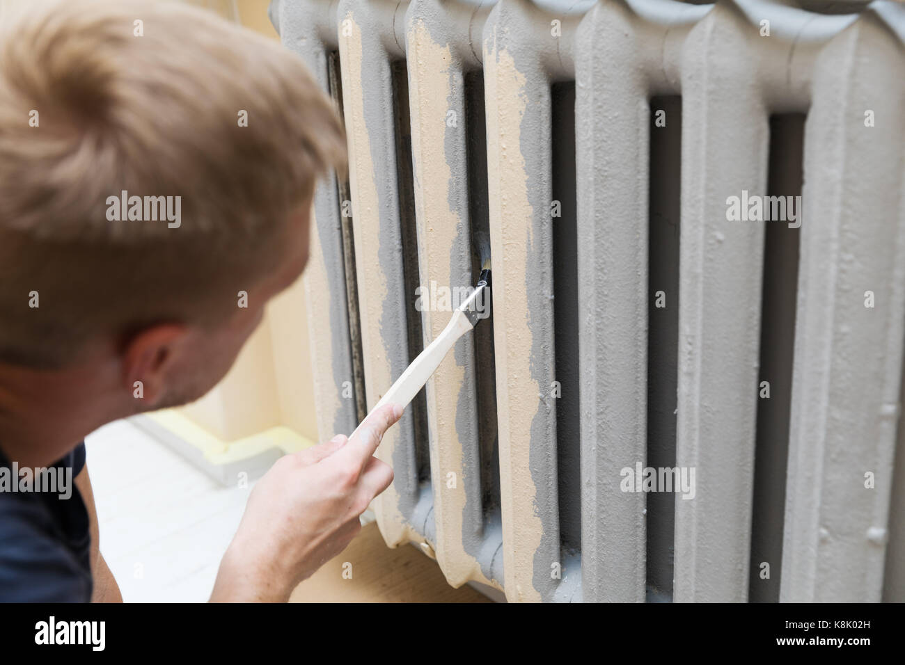 worker painting a heating radiator with paint brush Stock Photo Alamy