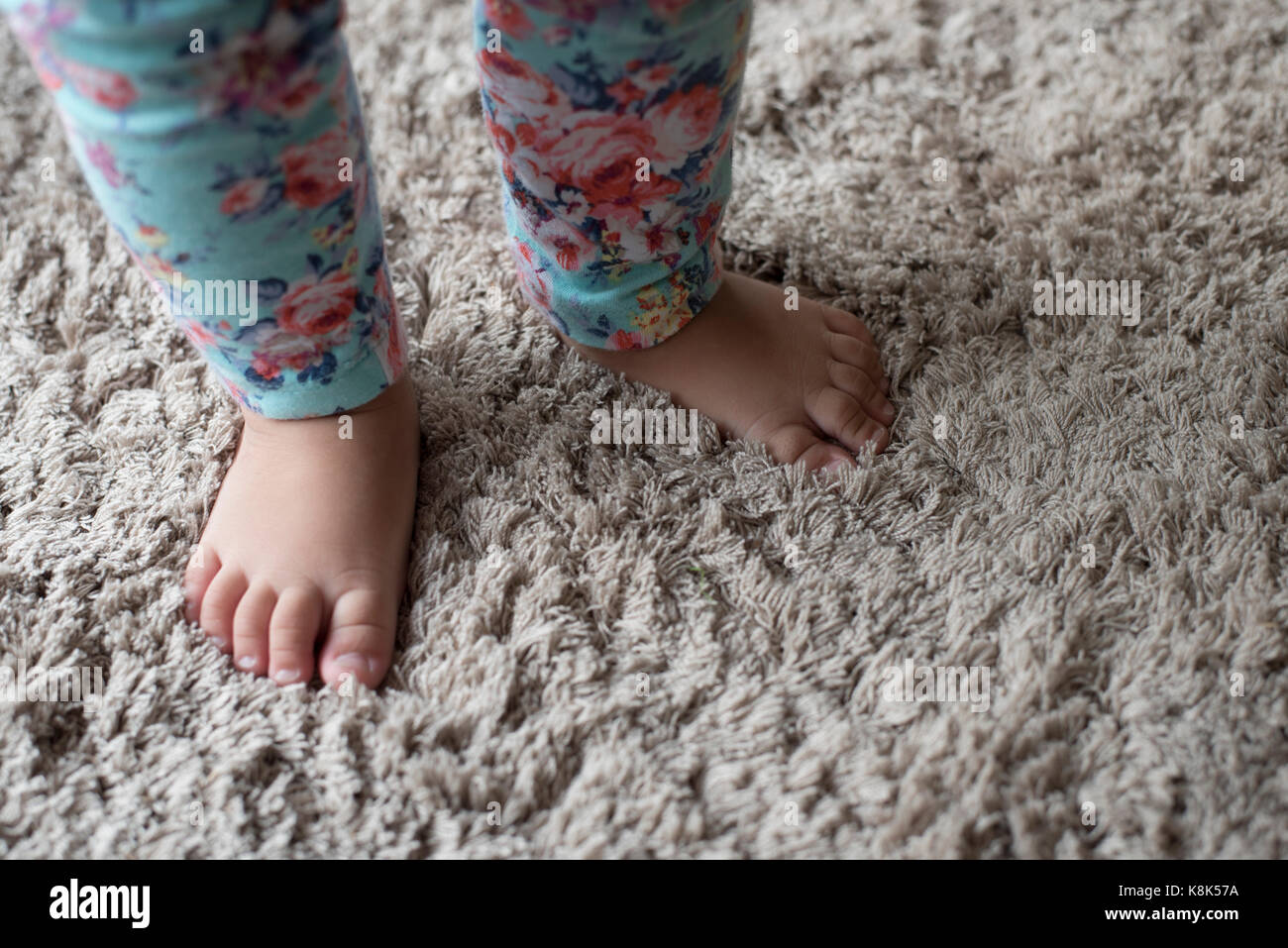 photo of a baby standing on a thick carpets (selective focus) Stock Photo