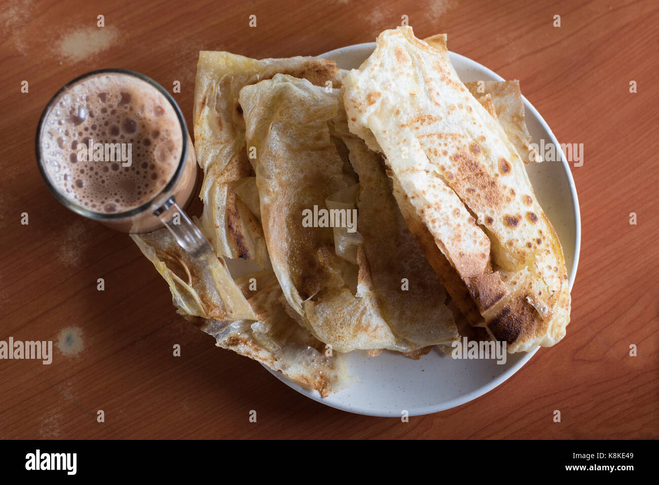 flatbread and tea with milk.also called roti canai and teh tarik by malaysian people.its a famous and popular meal in malaysia.everyday food Stock Photo