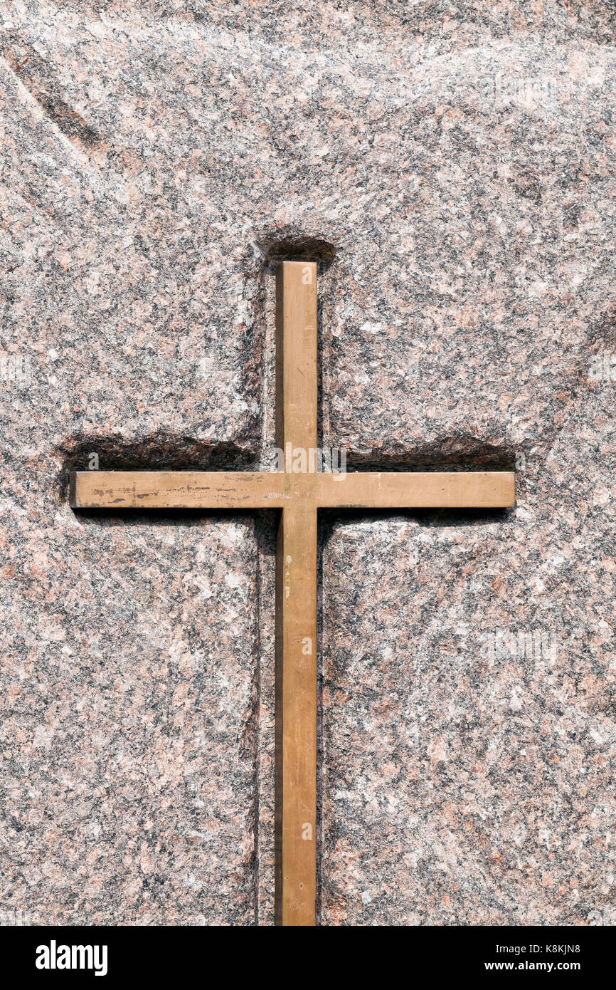 A wooden Catholic cross fixed on a stone. Religious symbols close-up photo Stock Photo