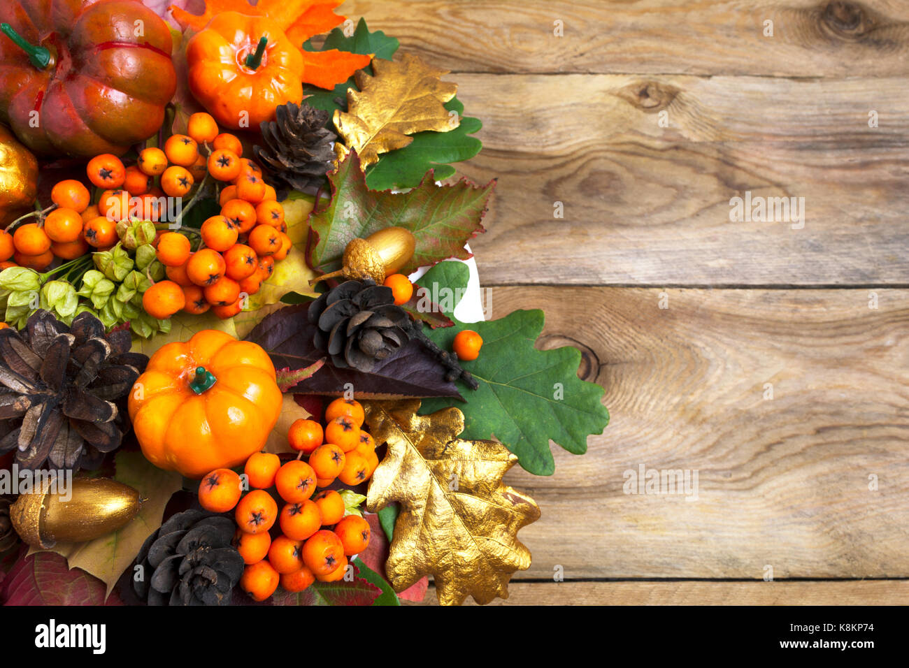 Fall arrangement with pumpkins and autumn leaves on the left side of ...