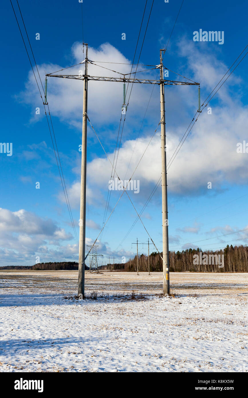 electric poles photographed in the winter season. On the ground is snow drifts after a snowfall. The sky in the background. Stock Photo