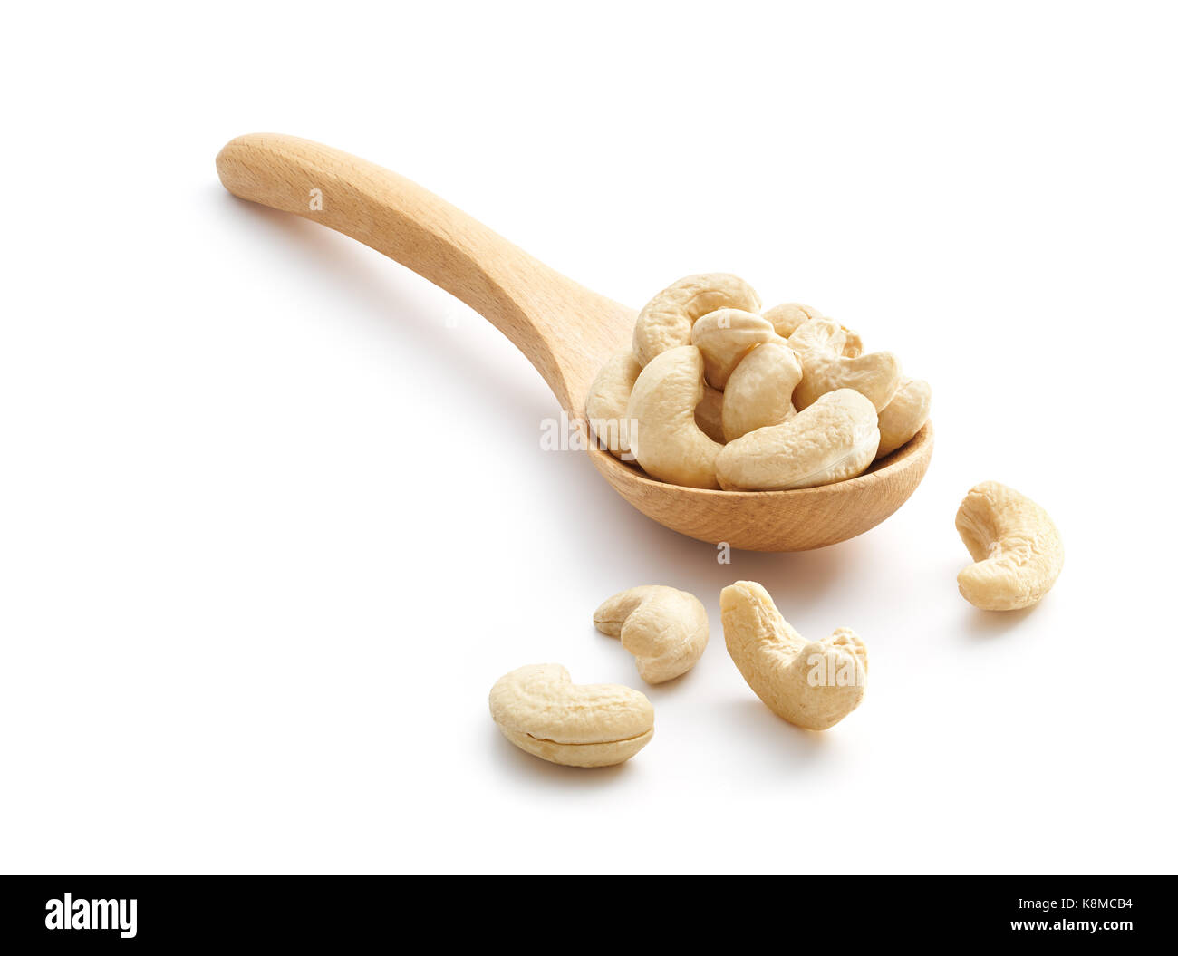 Cashew Nuts on wooden spoon isolated over white background Stock Photo