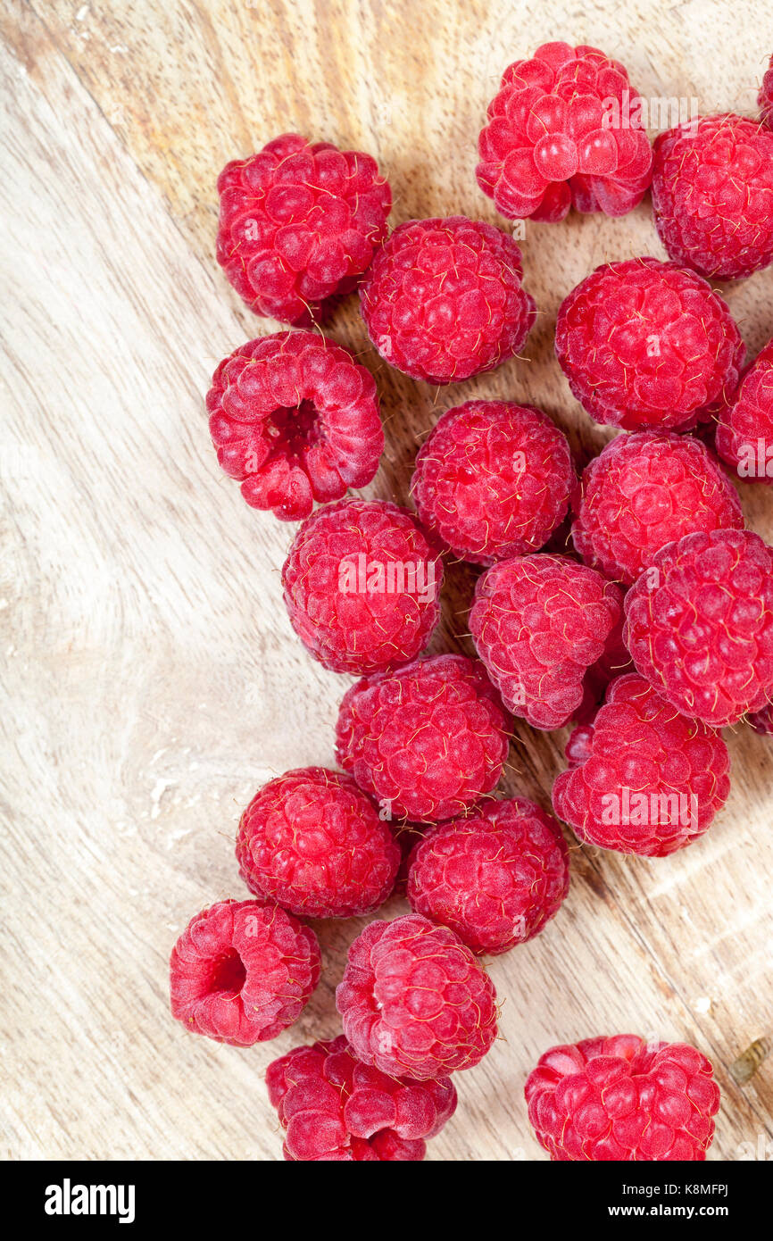 Ripe raspberries on a wooden table. Photographed close-up Stock Photo ...