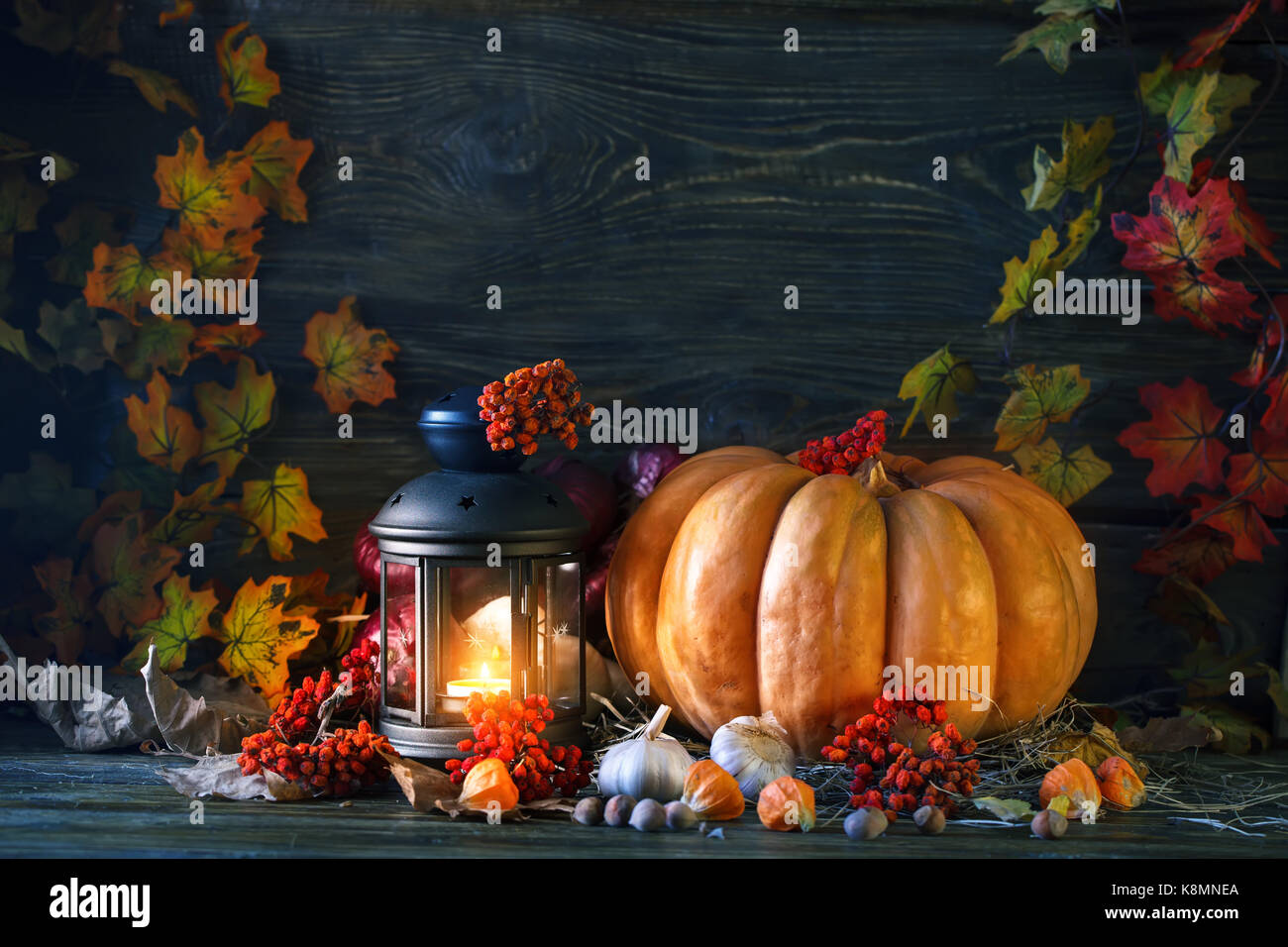 The wooden table decorated with vegetables, pumpkins and autumn leaves ...