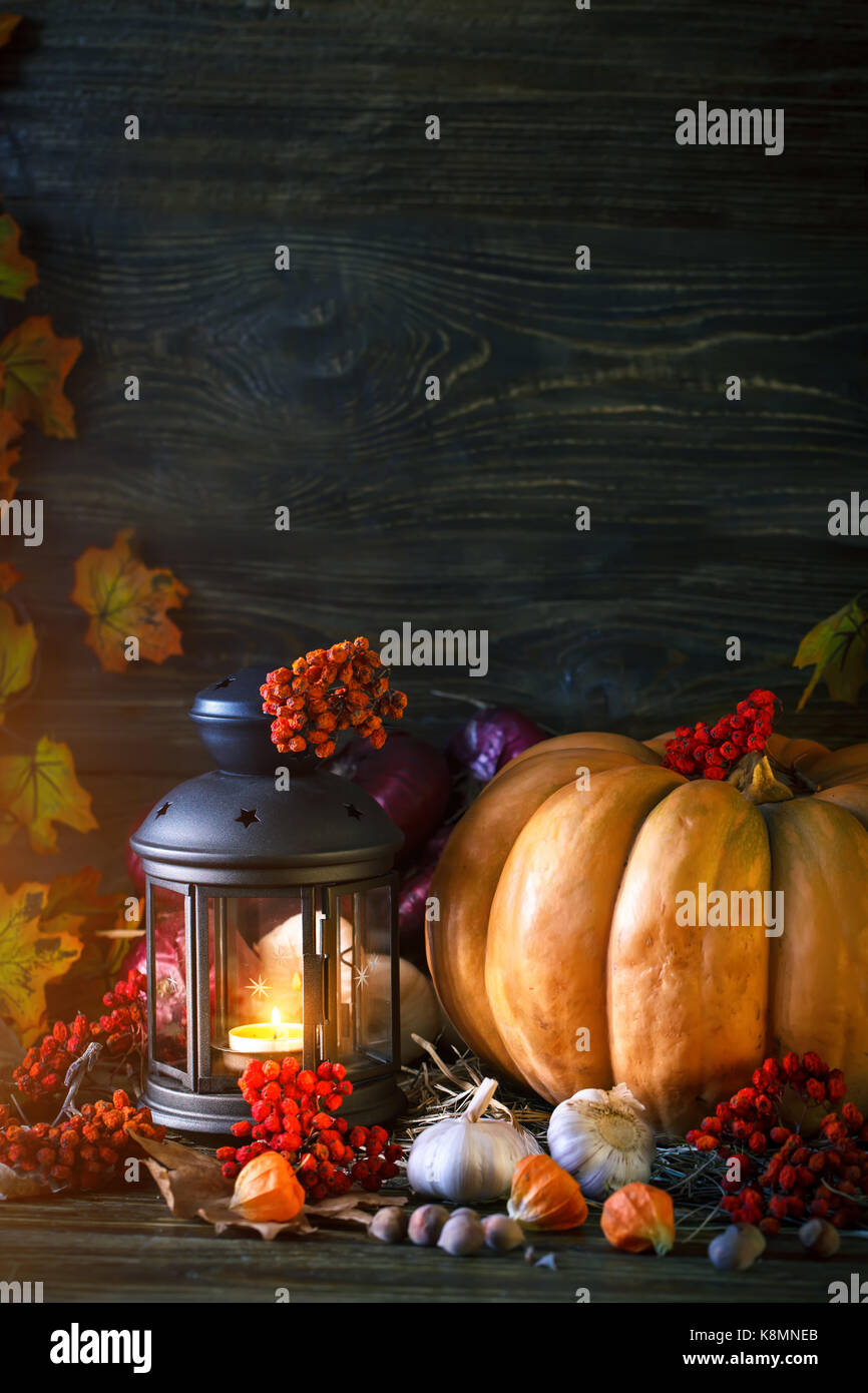 The wooden table decorated with vegetables, pumpkins and autumn leaves ...