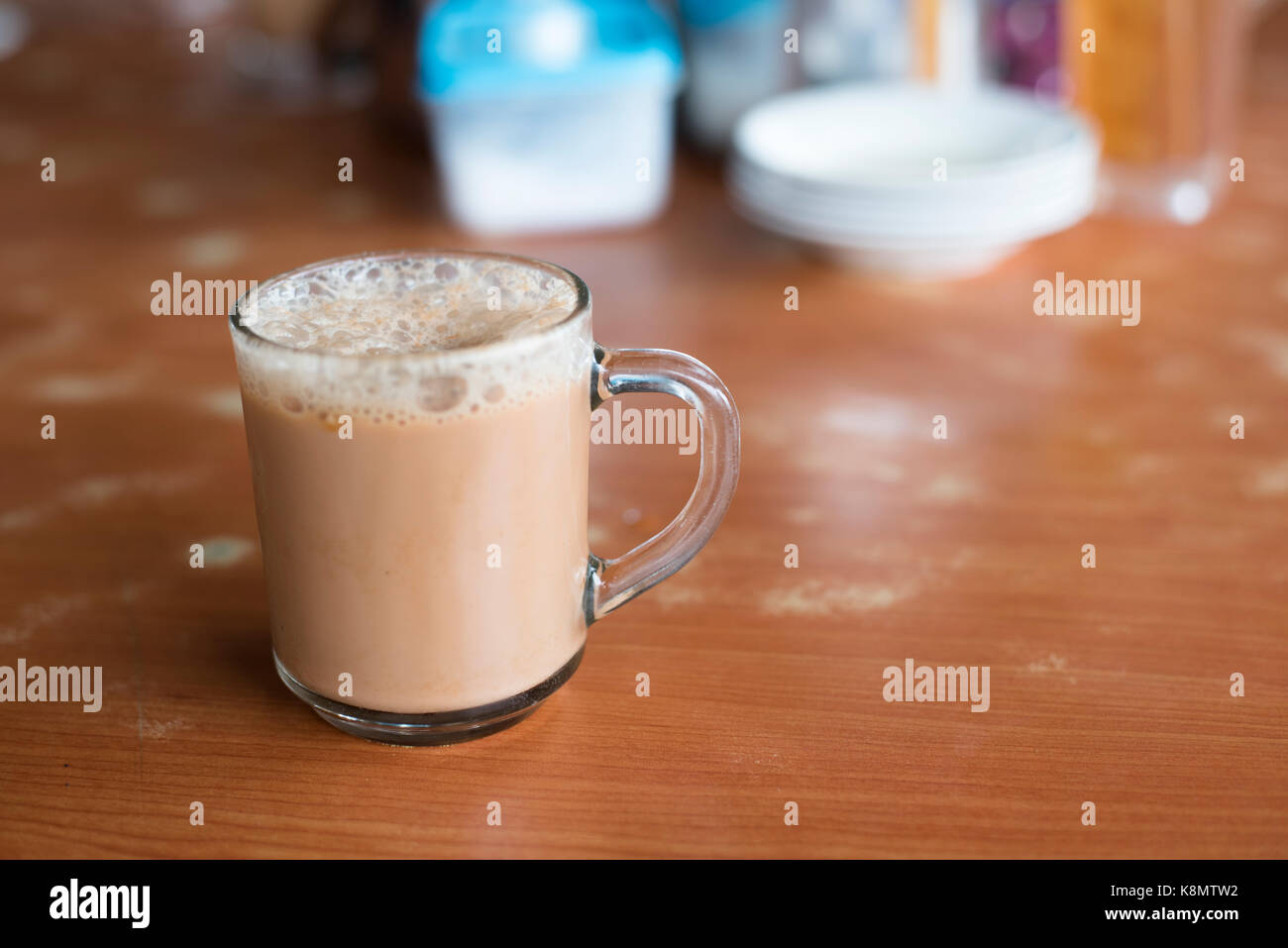 a glass of tea with milk on a table at mamak restaurant.famous or popular drink in malaysia.Malaysian favorite drink known as Teh Tarik.signature menu Stock Photo