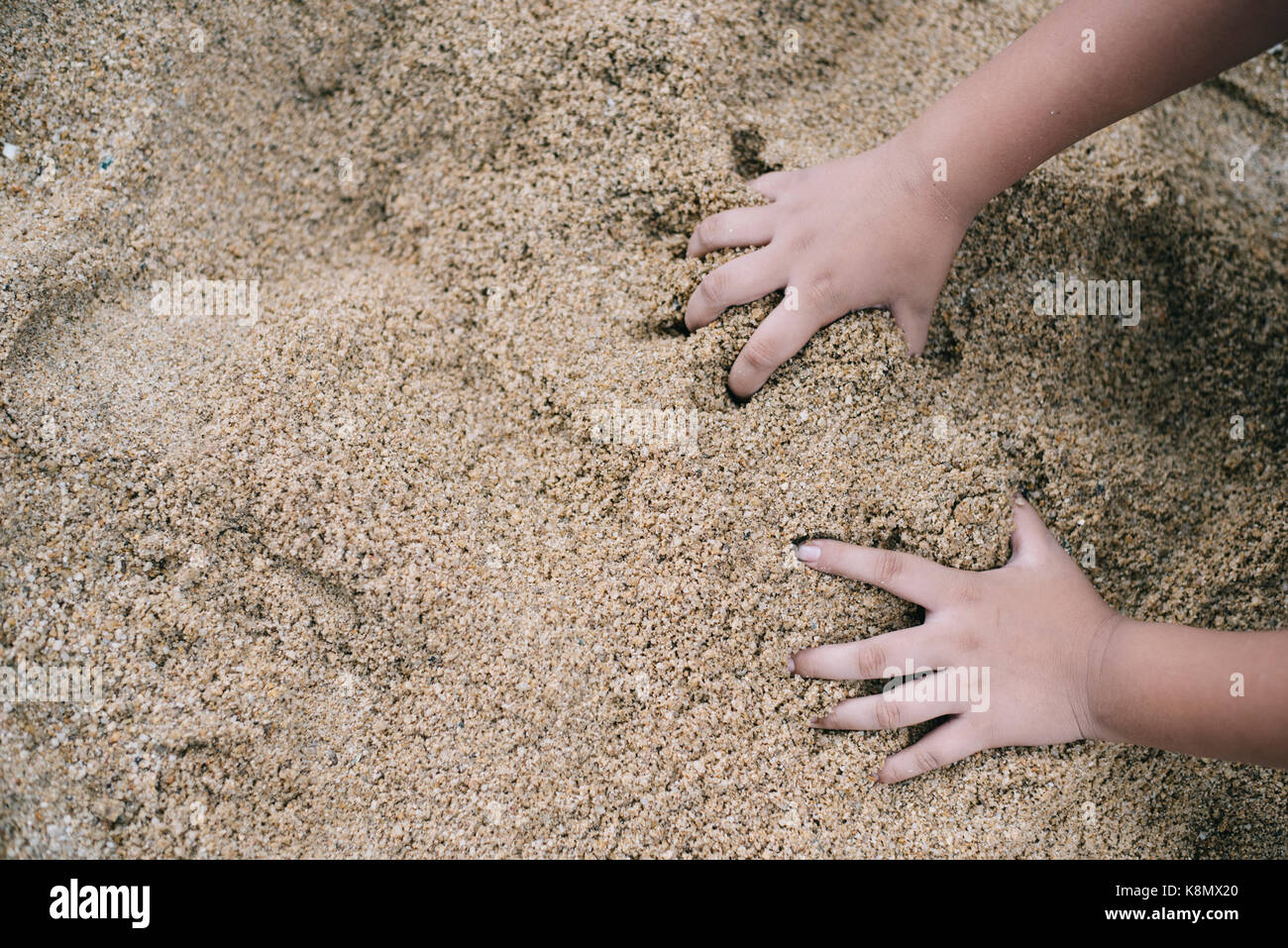 kid playing sand with hand (selective focus).kids growth developmant,kids activity,kids hygiene concept Stock Photo