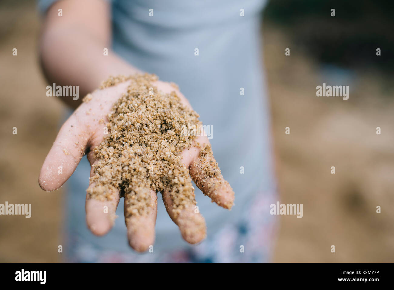 kid showing a sand with hand (selective focus).kids growth developmant,kids activity,kids hygiene concept Stock Photo