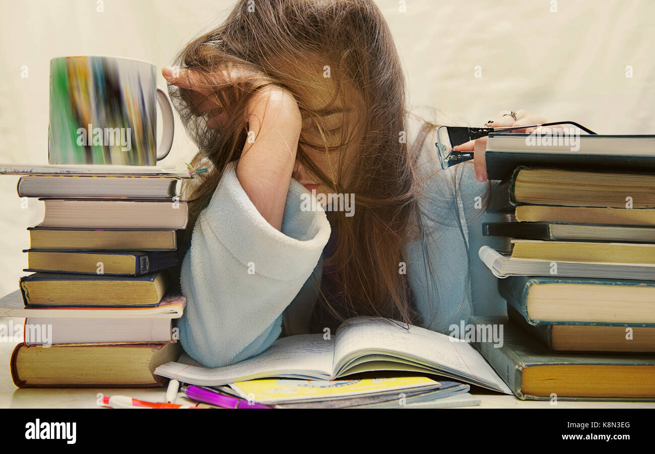 people, education, session, exams and school concept - tired student girl or young woman with books sleeping Stock Photo