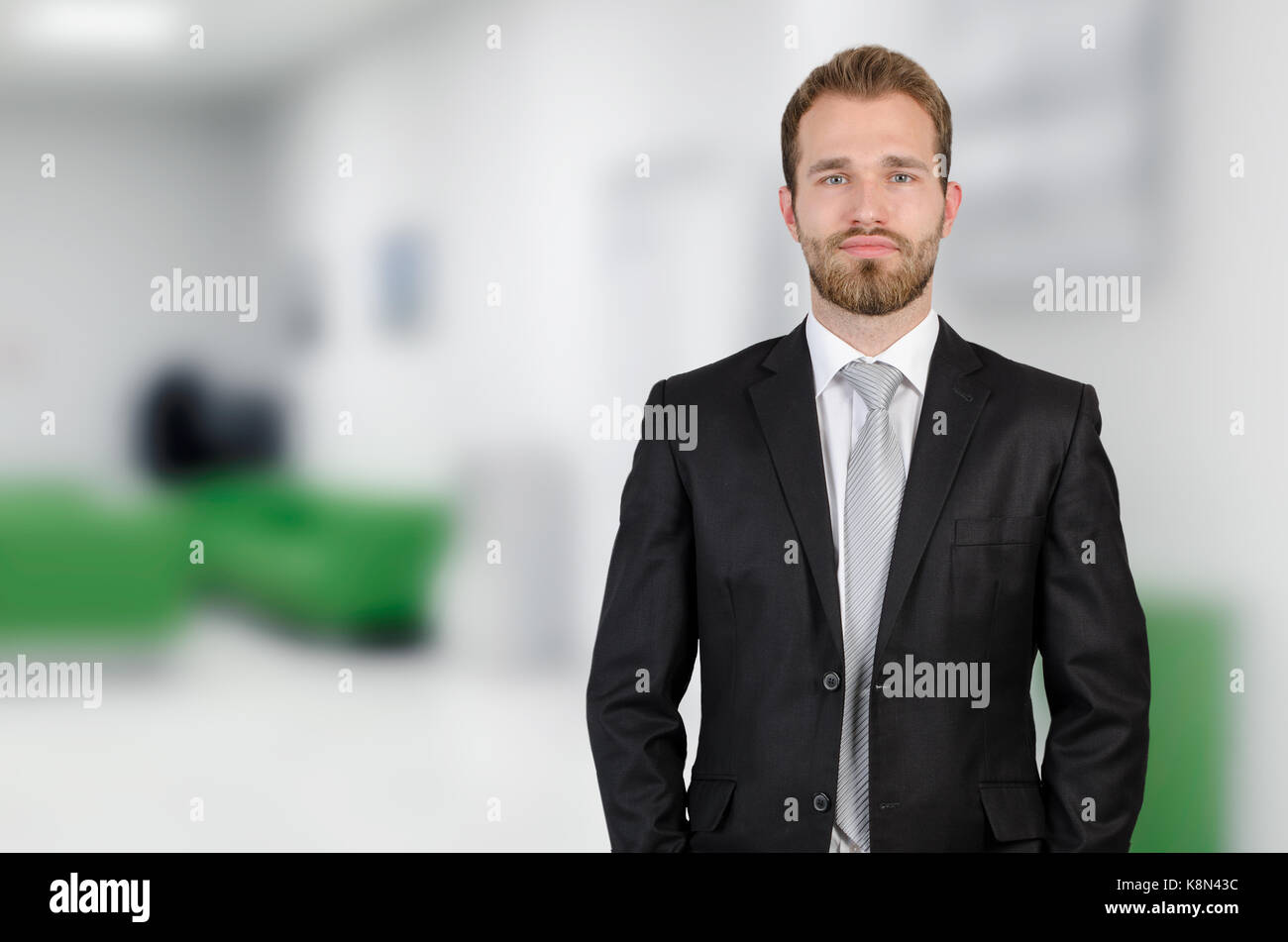 Portrait of young businessman standing in modern white office Stock Photo