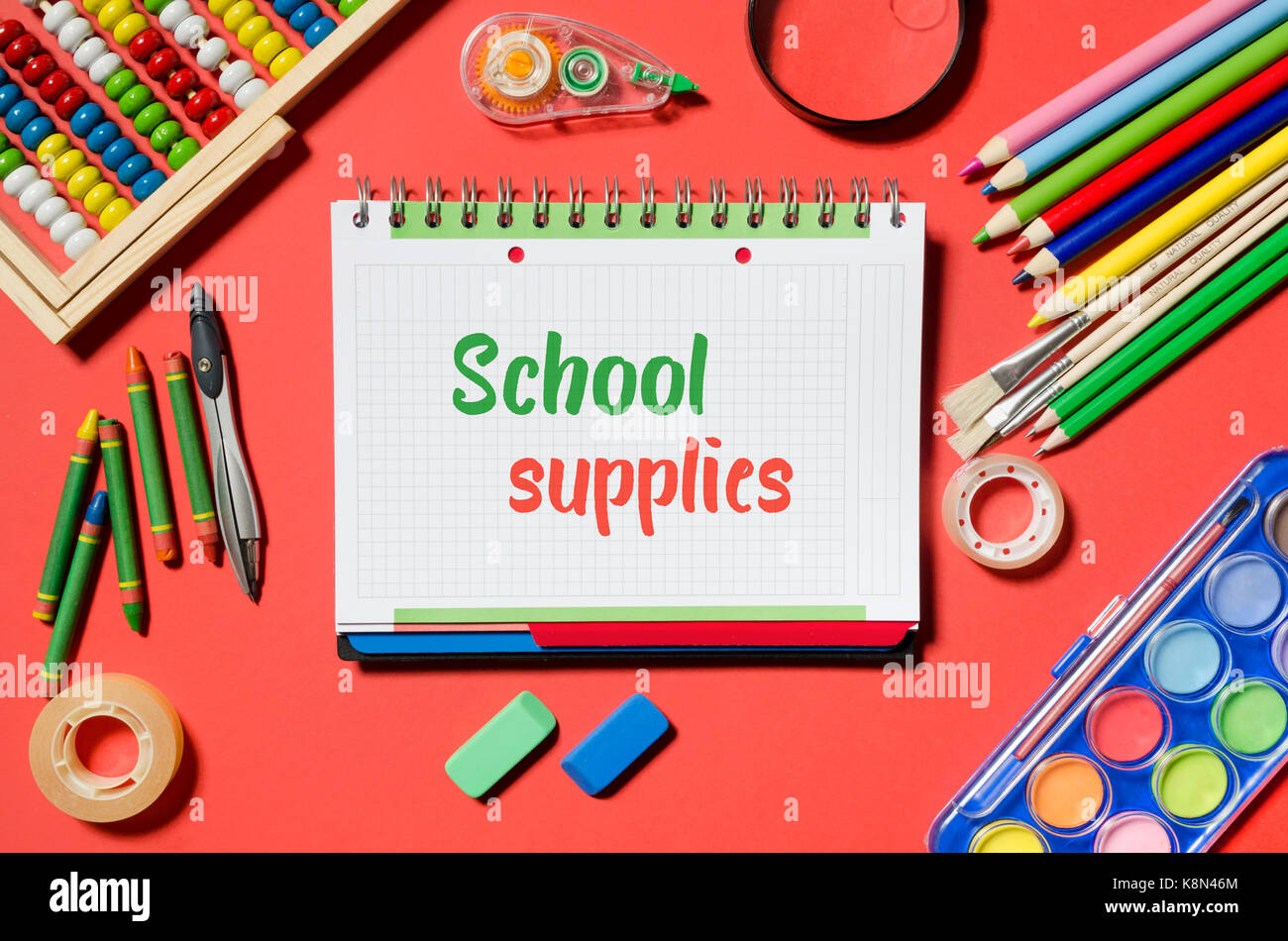 https://c8.alamy.com/comp/K8N46M/notepad-with-school-supplies-words-and-office-stationery-red-background-K8N46M.jpg