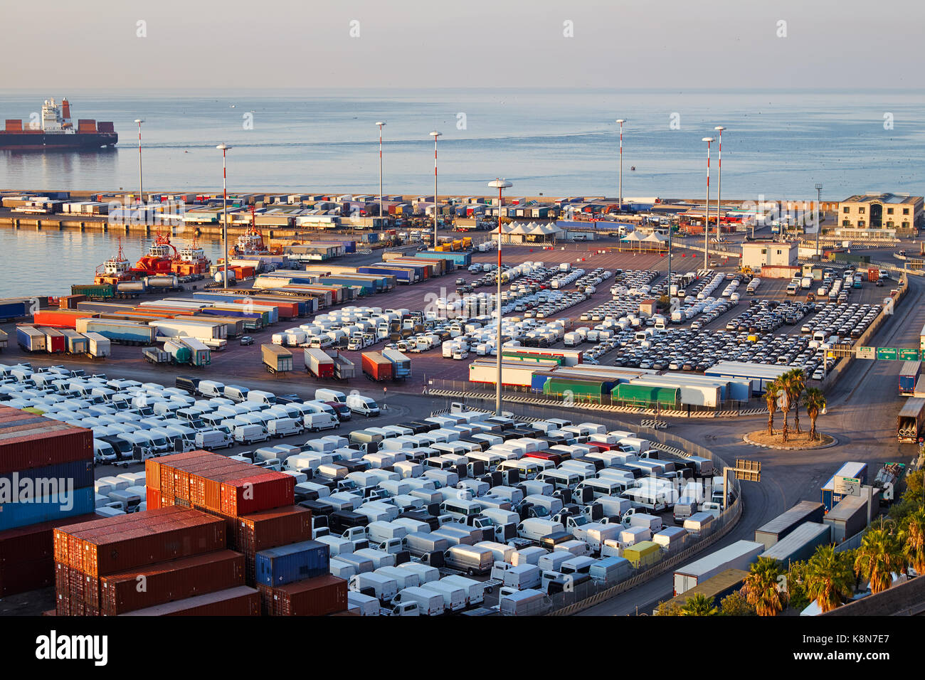 Port terminal with containers, new cars and wagons in the early morning Stock Photo