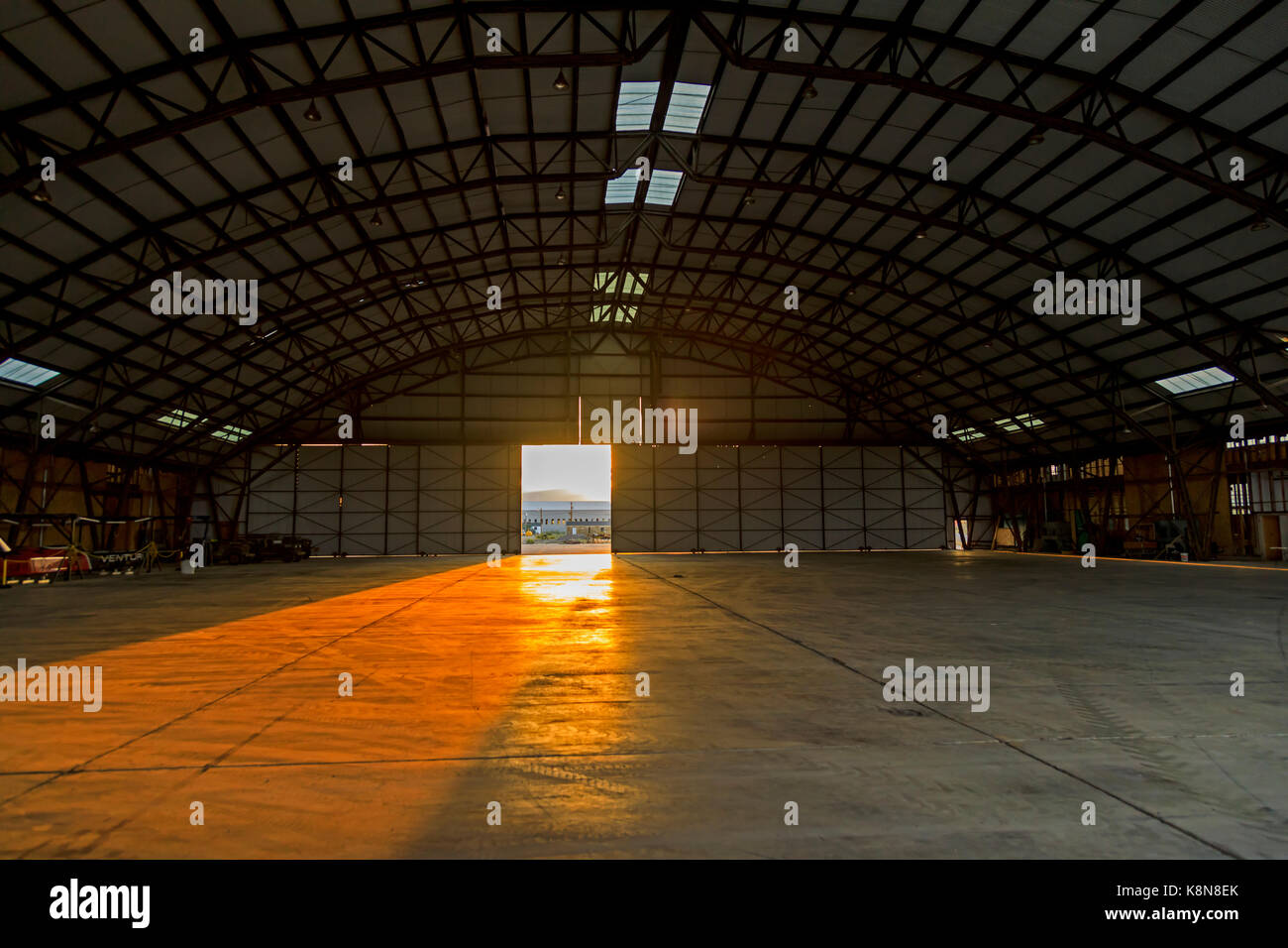 The setting sun shines through the front door into the interior of the Enola Gay Hangar at the Historic Wendover Airfield in Wendover, Utah, USA. Stock Photo