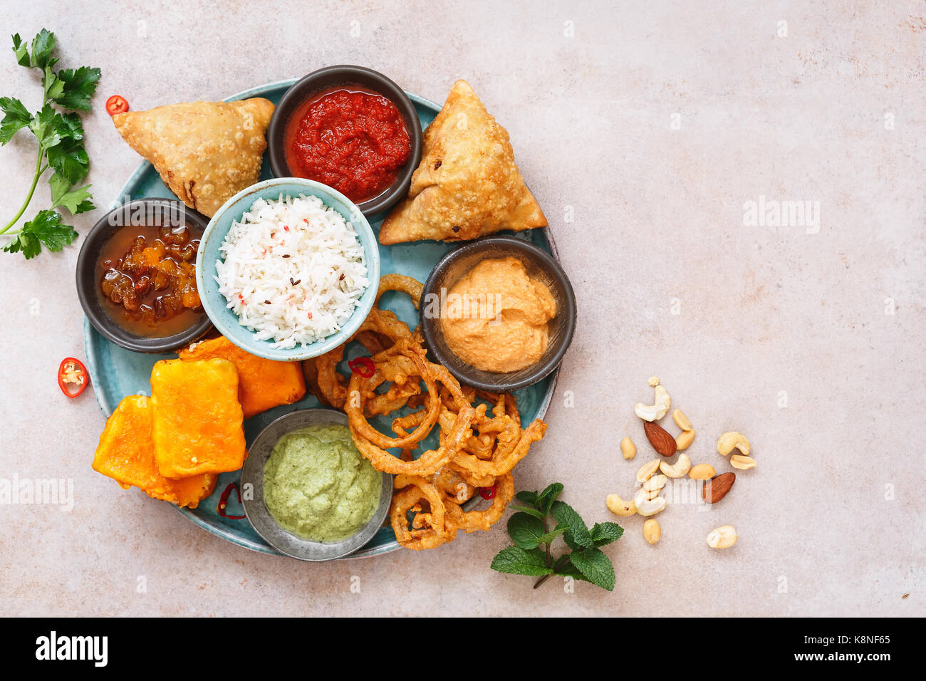 Indian vegetarian thali with jeera rice, different snacks and dips. Top view, blank space Stock