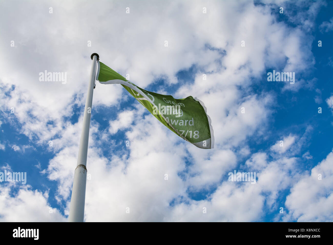 Green flag, blowing in the wind, on a pole. Represents the Green Flag Award 2017/18 awarded to the Severn Valley Country Park, Alveley, Shropshire, UK Stock Photo