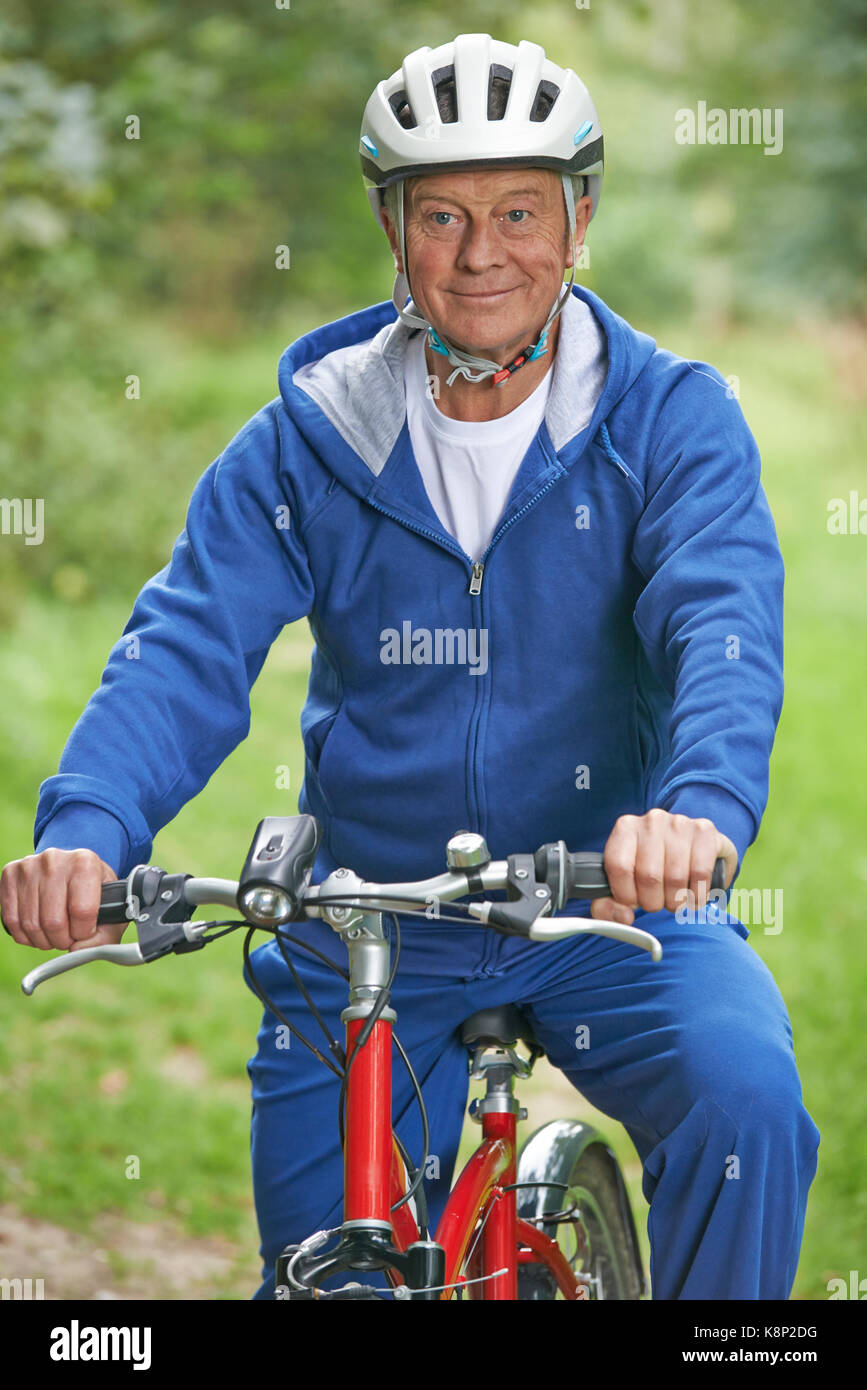 Senior Man Enjoying Cycle Ride In The Countryside Stock Photo