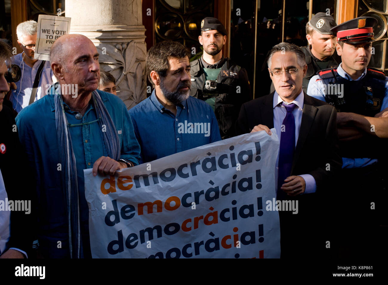 Barcelona, Catalonia, Spain. 20th Sep, 2017. Pro-independence leaders Lluis LLach (L) Jordi Sanchez (C) and Ramon Tremosa (R) hold a banner reading Democracy close to Catalan Economy Ministry in Barcelona. Spain's Guardia Civil police have detained senior Catalan officials and raided regional government ministries involved in organising a independence vote. Catalan government aims to celebrate a referendum on independence next first october, the Spanish government is frontally opposed to the referendum and consider it illegal. Credit: ZUMA Press, Inc./Alamy Live News Stock Photo