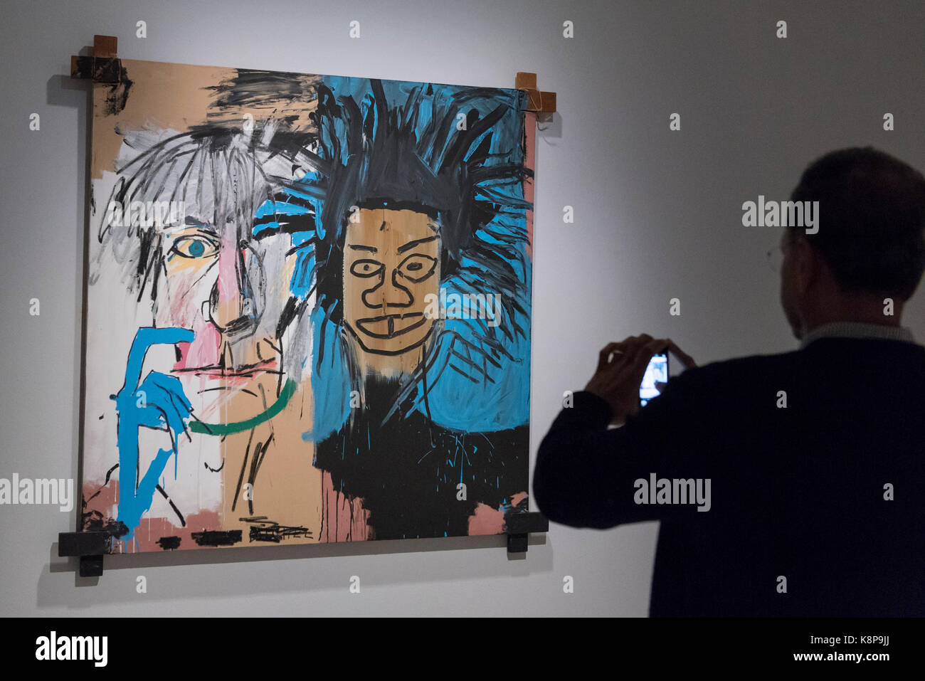 London, UK. 20 September 2017. A man views "Dos Cabezas", 1982, by Jean-Michel  Basquiat. Preview of "Basquiat: Boom for Real", the first large-scale  exhibition in the UK of the work of American