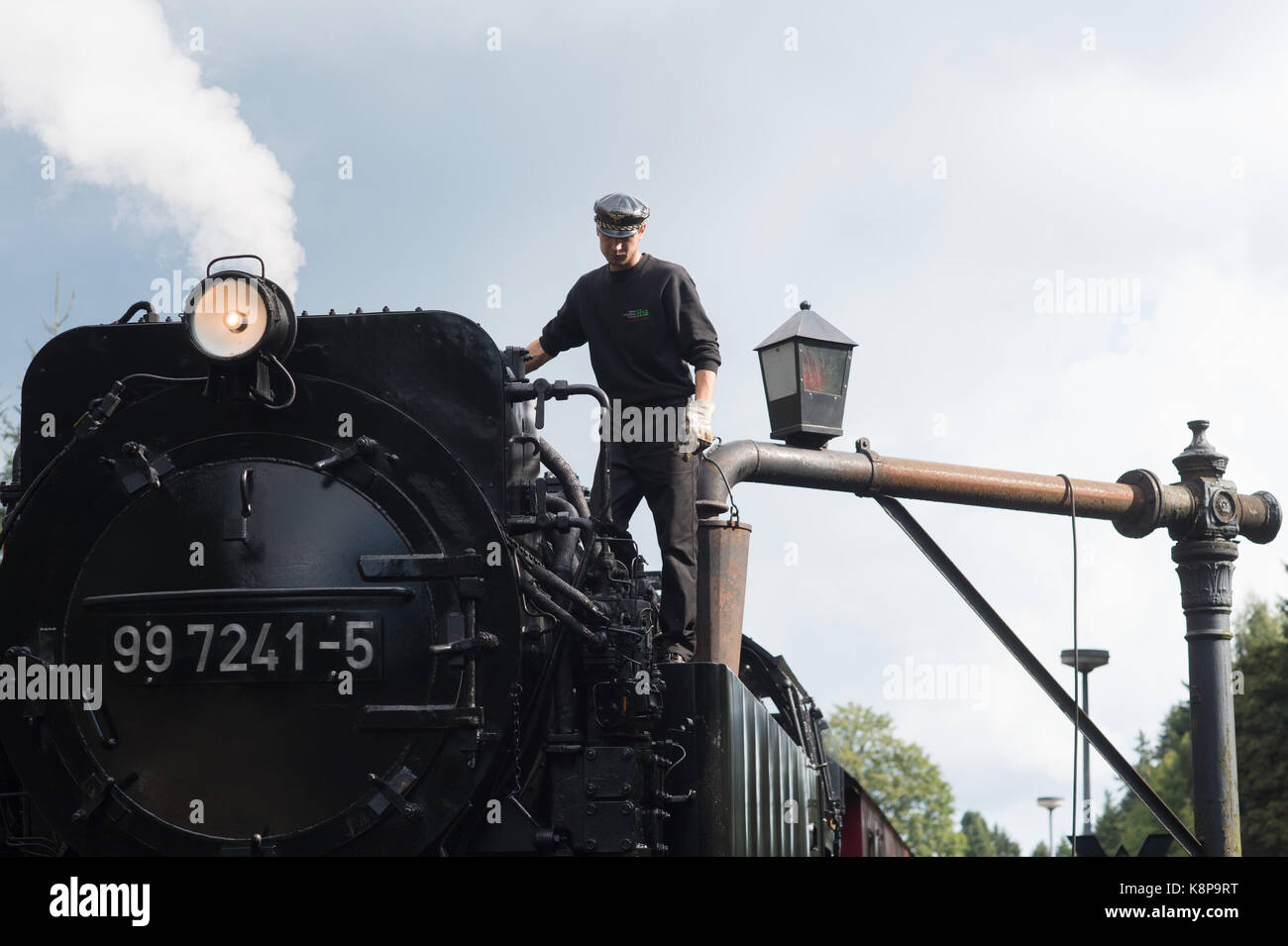 Drei Annen Hohne, Germany. 18th Sep, 2017. Tobias Hinsche of the Harzer Schmalspurbahn (lit. Harz narrow gauge railway) filling the newly built locomotive 99 7241 - 5, on which he works as a boilerman, at the station in Drei Annen Hohne, Germany, 18 September 2017. Credit: Klaus-Dietmar Gabbert/dpa-Zentralbild/ZB/dpa/Alamy Live News Stock Photo