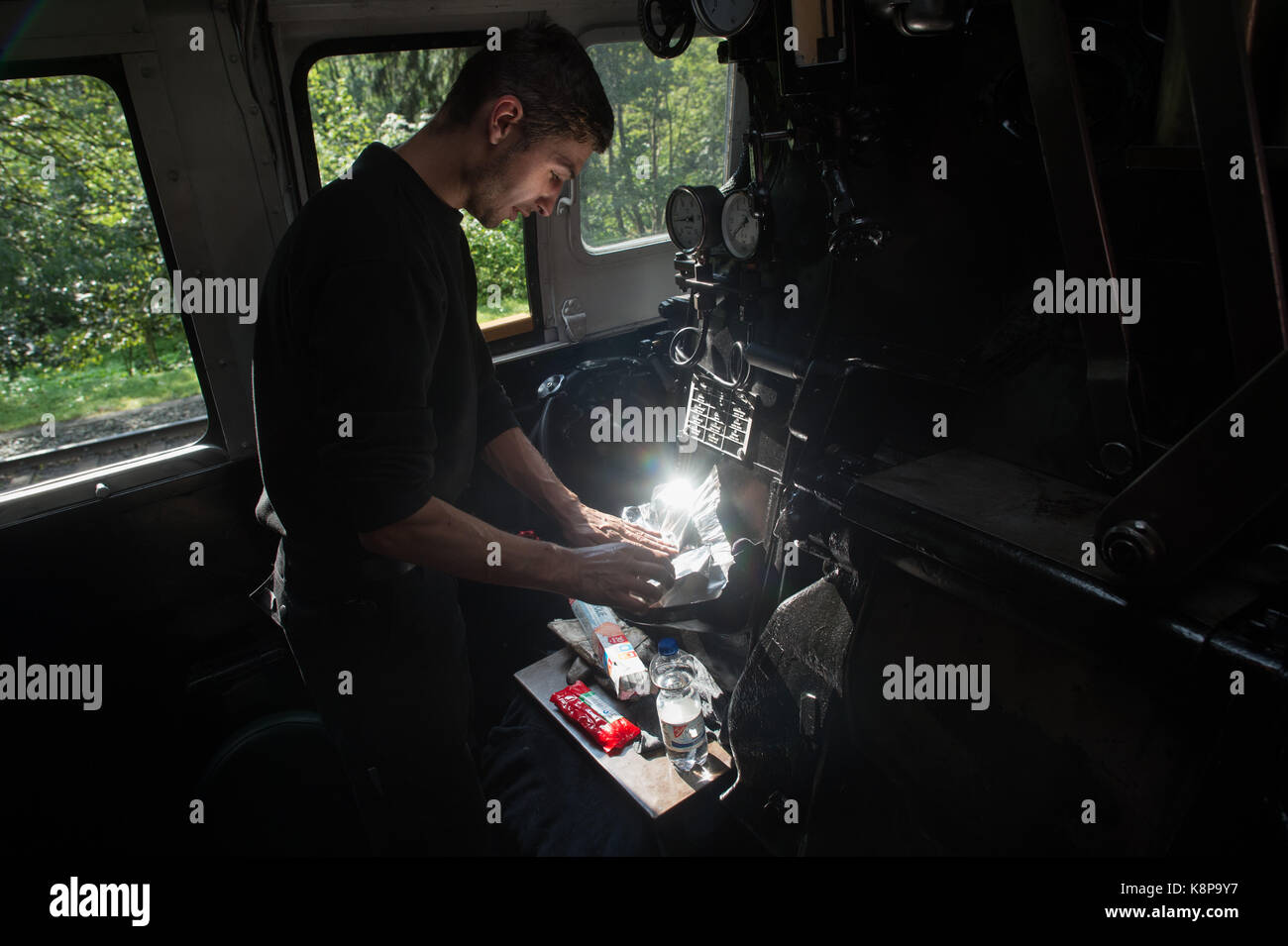 Schierke, Germany. 18th Sep, 2017. Tobias Hinsche of the Harzer Schmalspurbahn (lit. Harz narrow gauge railway) prepares his lunch on the journey from Drei Annen Hohne to Schierke, Germany, 18 September 2017. He is heating up sausages on the firebox hatch of the newly built locomotive 99 7241 - 5, on which he works as a boilerman. Credit: Klaus-Dietmar Gabbert/dpa-Zentralbild/ZB/dpa/Alamy Live News Stock Photo