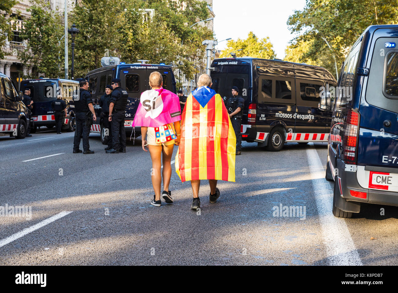 Barcelona, Spain - September 20, 2017: Couple walking between police cars towards demonstration for independence of Catalonia Credit: Jordi De Rueda Roigé/Alamy Live News Stock Photo