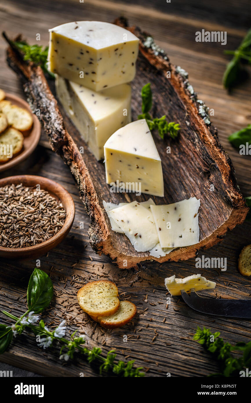 Still life of cheese on a bark with caraway seeds Stock Photo Alamy