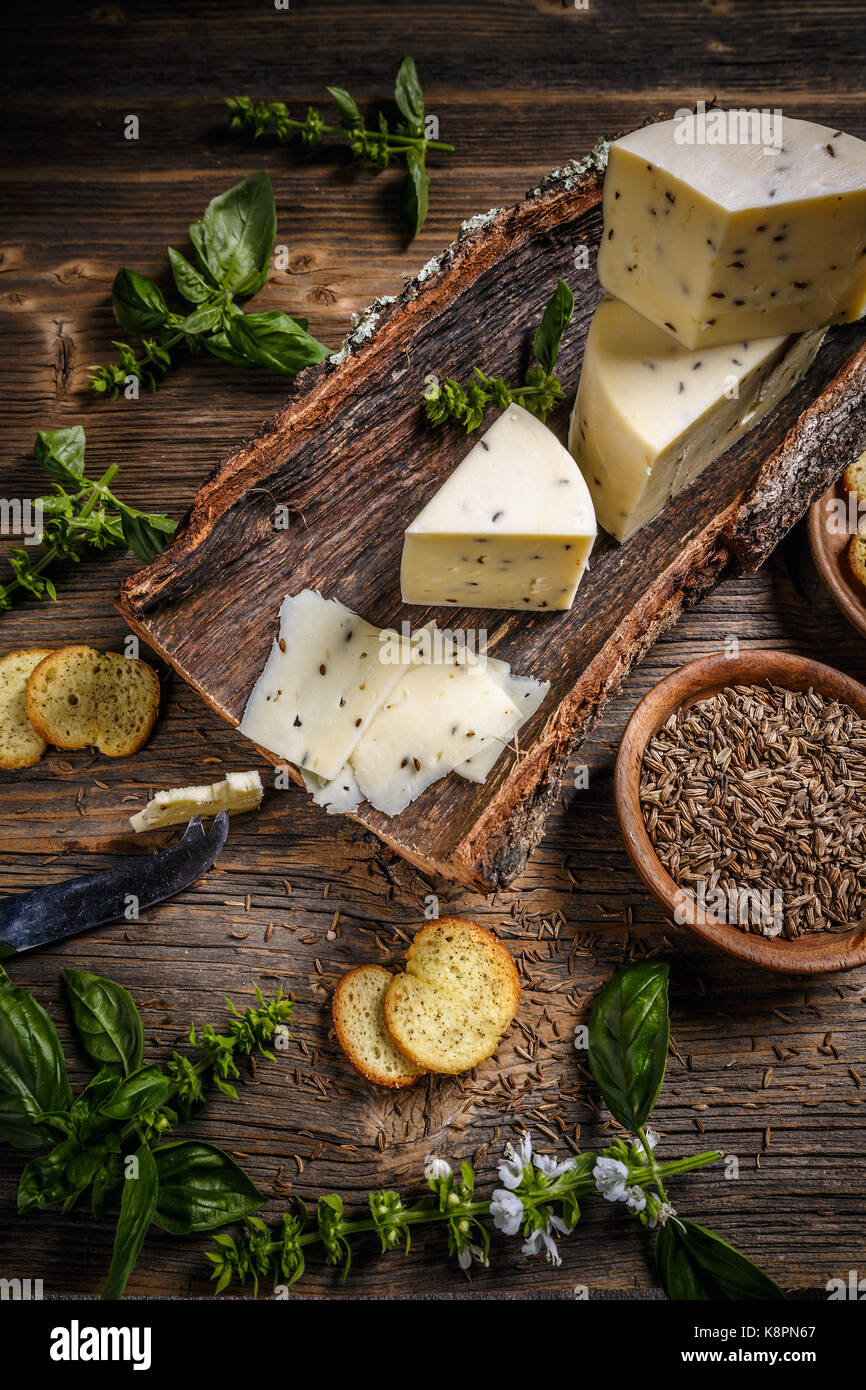 Cheese concept on a bark with caraway seeds Stock Photo Alamy