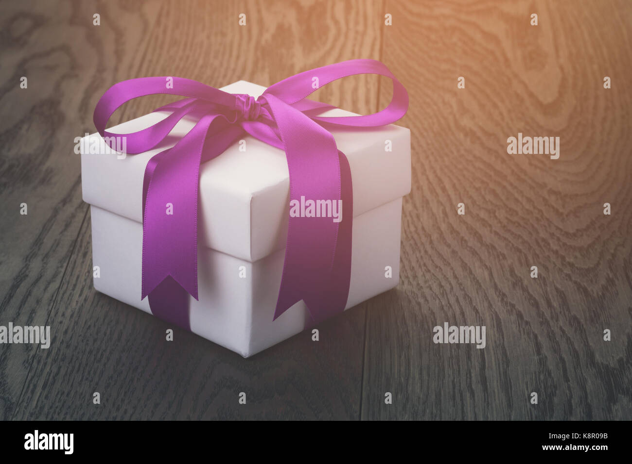 gift box with ribbon bow on old oak table Stock Photo