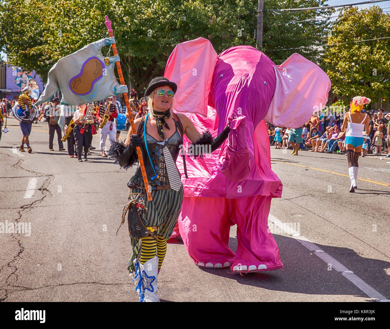 SEATTLE, WA - JUNE 22, 2013: An unidentified woman in a steampunk costume appears to be leading a pink elephant through the street during the annual F Stock Photo