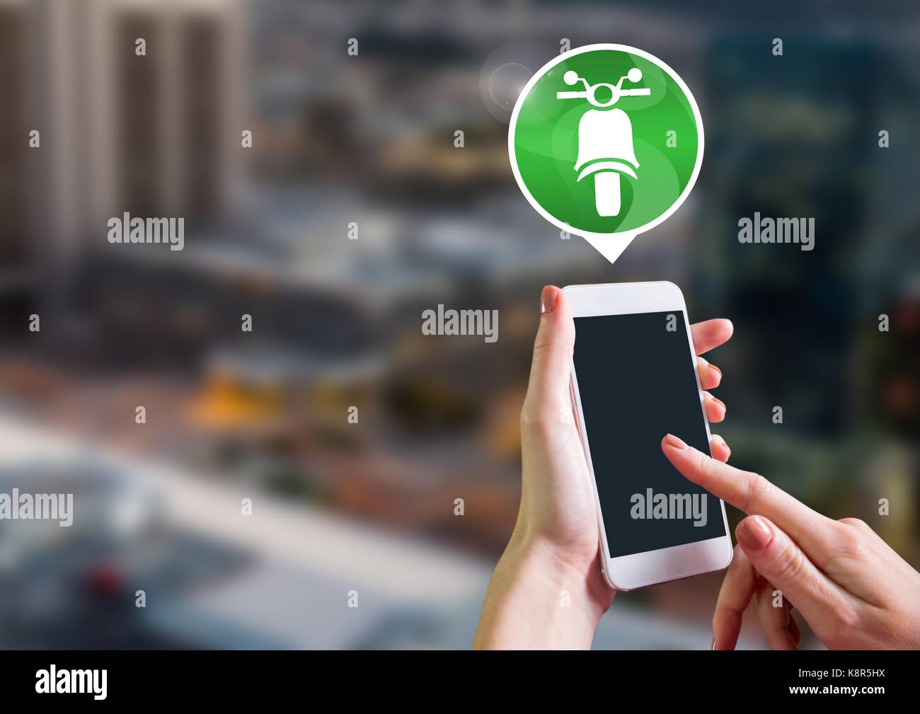 Digital composite of Hand holding phone with motorbike icon in city ...