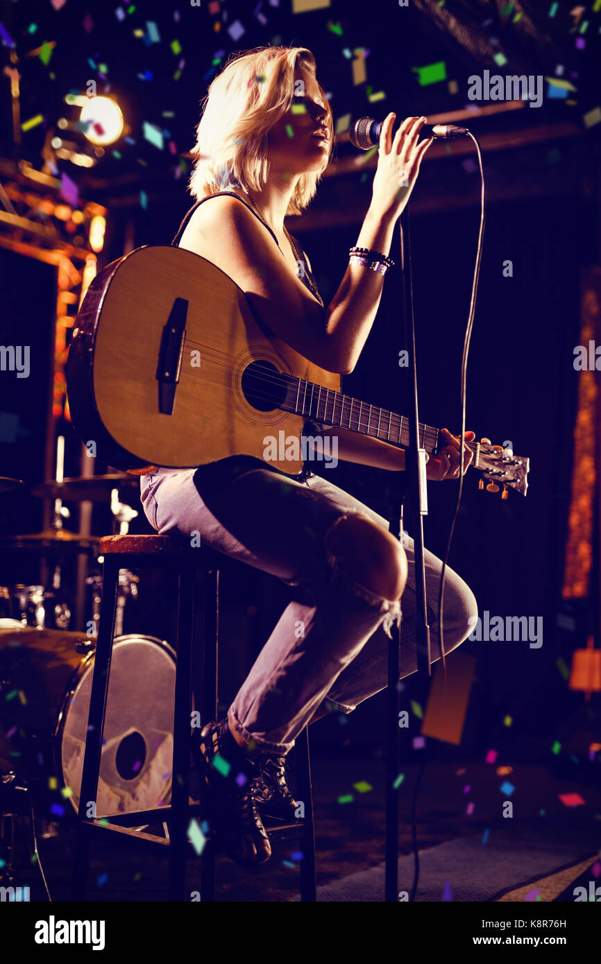 Singer Flying Performance Flying colours against performer singing while holding guitar at ...
