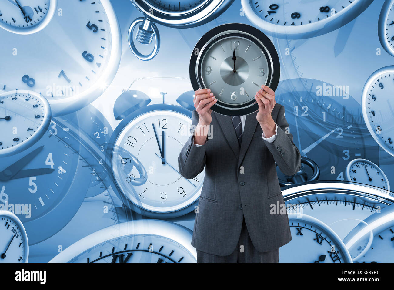 Businessman holding clock in front of his face against digital image of various clocks Stock Photo