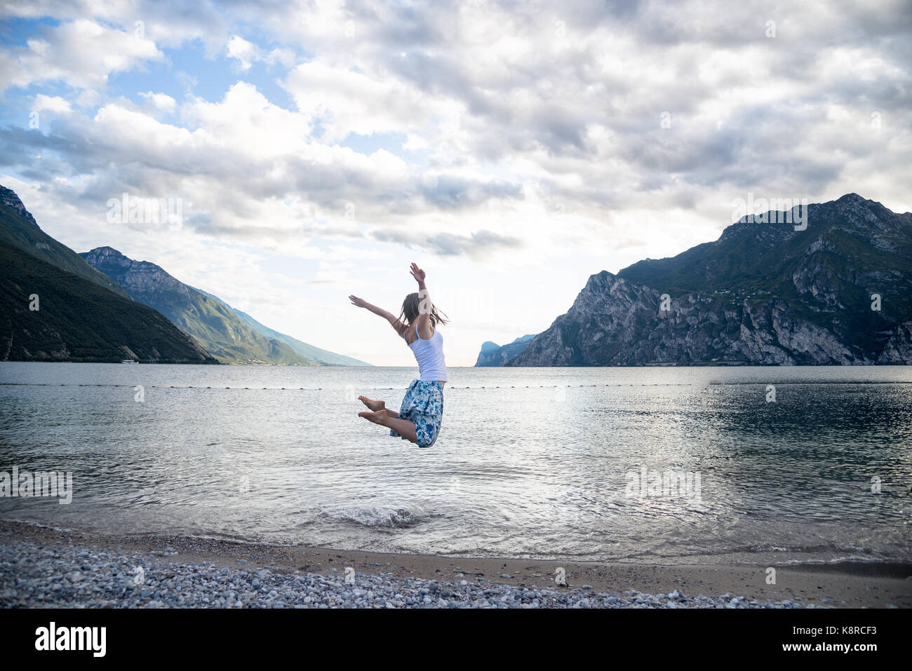 Woman jumping at the lake Stock Photo