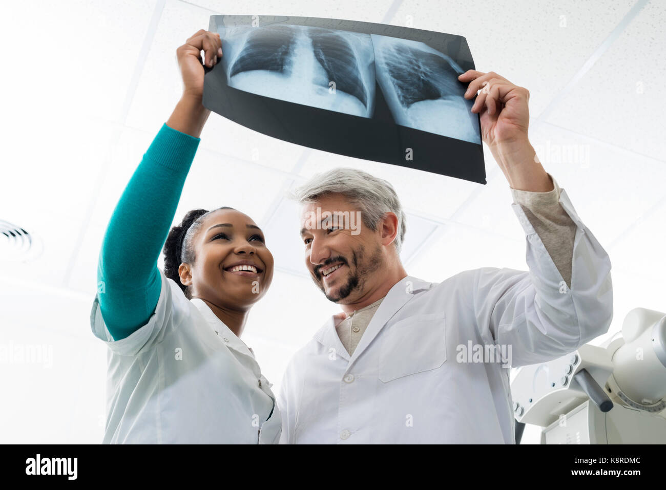 Smiling Male And Female Doctors Examining Chest X-ray In Hospita Stock Photo