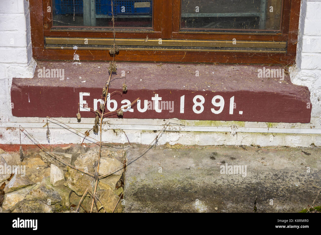 German lettering 'Built 1891' on a window sill of a historic factory building. Stock Photo