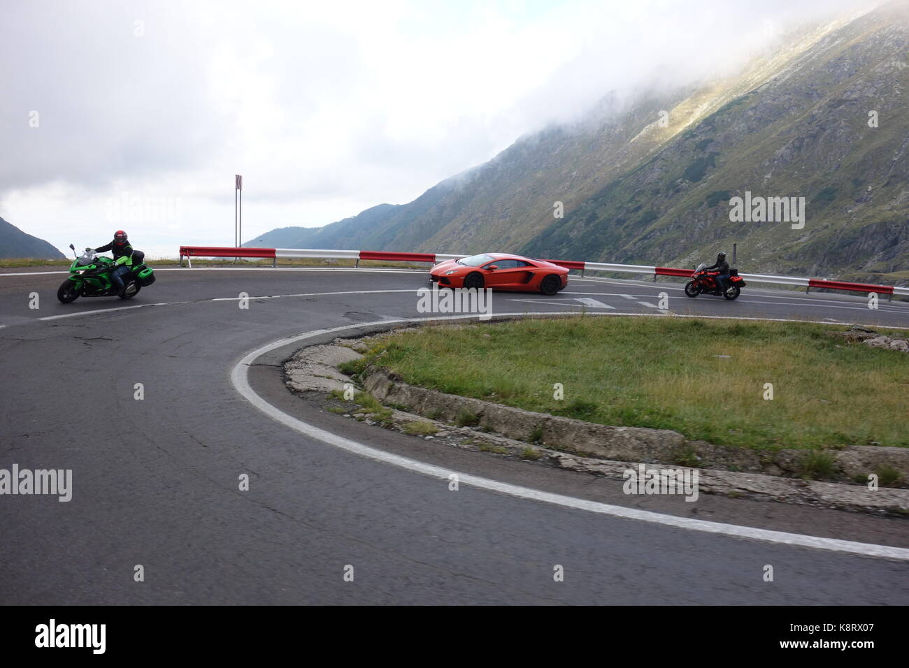 Beautiful orange Lamborghini Huracan and motorcycles drived on Transylvania region on the famous Transfagarasan road. Romania August 2017 Stock Photo